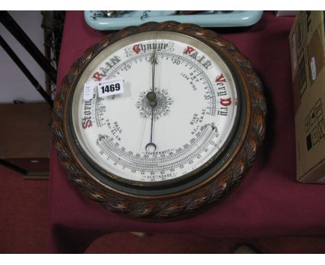 An Early XX Century Barometer, oak rope twist surround, white enamel face, diameter 27cm.