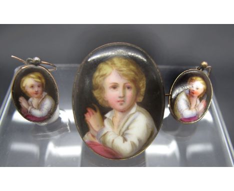 An Oval Ceramic Panel Brooch, depicting a fair haired boy; together with a pair of matching earrings stamped "9ct".