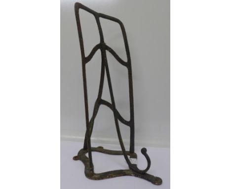 A metal wall mounted bracket for a saddle