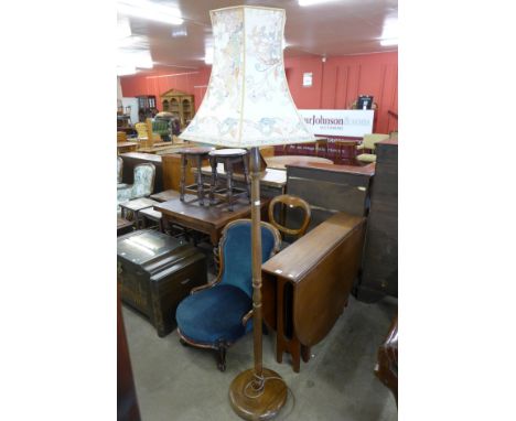 A teak drop-leaf table and a standard lamp