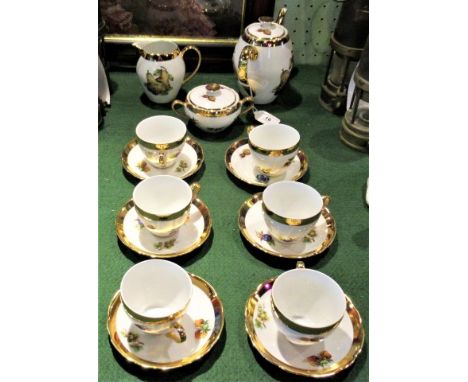 A Czechoslovakian tea service with gilt and fruit decoration, comprising: six cups, saucers, teapot, milk jug and sugar bowl.