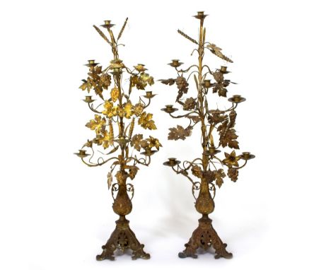 A PAIR OF 19TH CENTURY CONTINENTAL GILT METAL SCROLLING CANDELABRA in the form of grapevines and leaves on foliate tripod bas