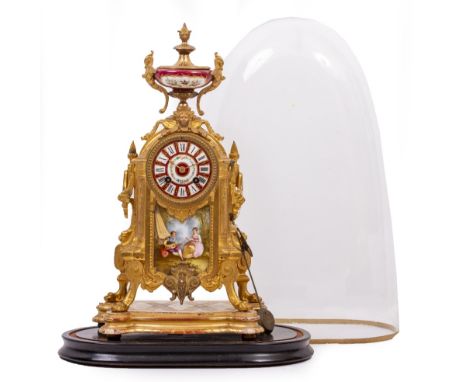 A 19TH CENTURY GILT SPELTER FRENCH MANTLE CLOCK with porcelain mounts, urn finial and on a shaped gilt wooden base, complete 