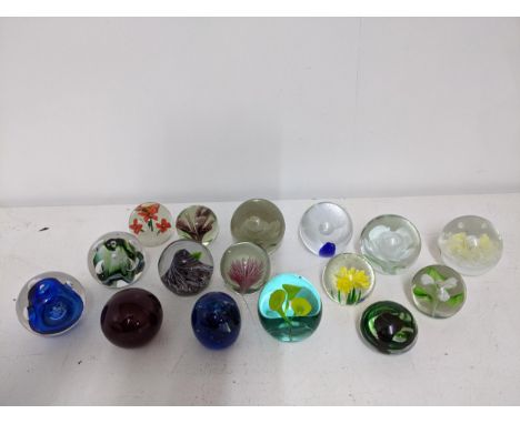 A selection of glass paperweights to include two signed Adam Jablonski abstract weights, a Whitefriars ruby controlled bubble