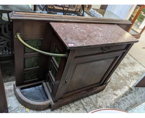 A Victorian oak hall side cabinet with pink variegated marble top flanked by brass sectioned stick stands with inset tiles, a