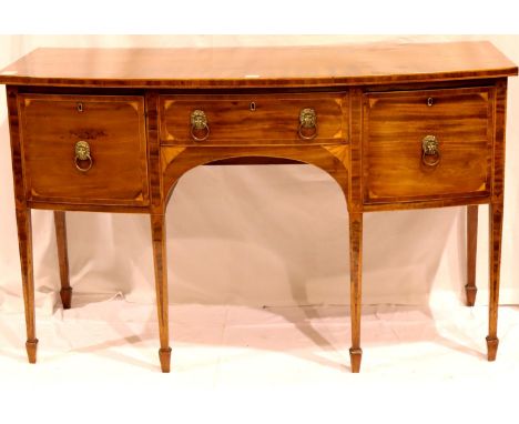 A Regency period inlaid mahogany sideboard, the polished top quartered, the three drawers with lion mask handles and raised o