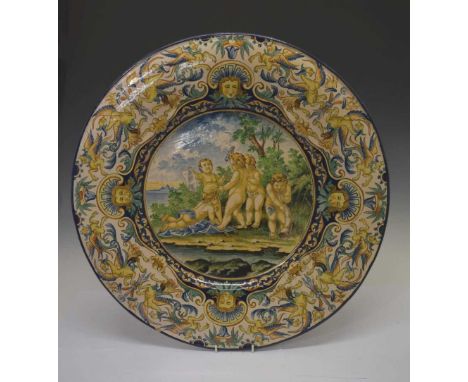 Large Italian Castelli-style maiolica charger, circa 1900, the centre painted with five cherubs or amorini in a coastal lands