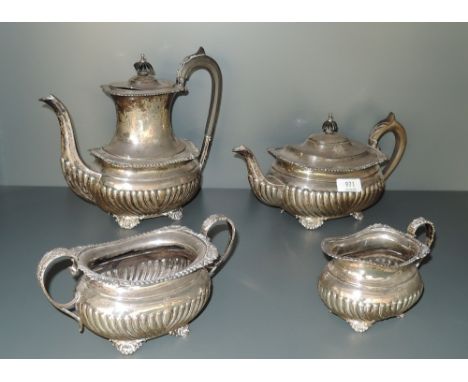 A silver four piece tea set having gadrooned decoration with monogram to side, hard wood handles, moulded decoration to brack