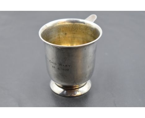 A hallmarked silver cup, of flared cylindrical form with applied ring handle and circular foot, rubbed marks for Birmingham 1