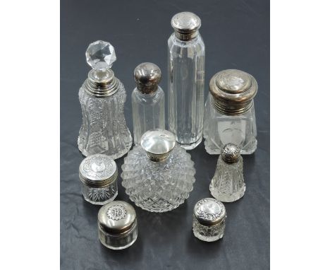 A selection of silver topped glass dressing table jars and scent bottles, to include a small 'Rotary Club of Manchester' jar,