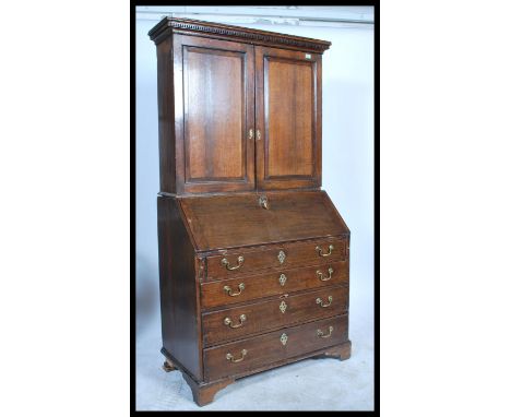 A 19th Century Georgian mahogany bureau bookcase, the upper shelved bookcase with a short cornice and enclosed by panelled do