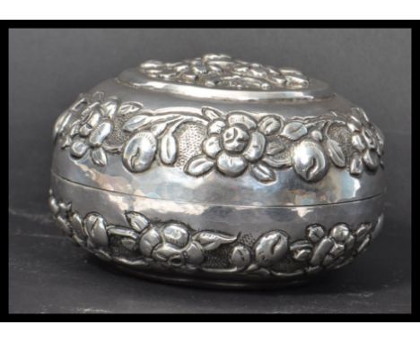 A 19th century Chinese silver (tested) lidded trinket pot cast in relief with flowers and leaves. Weighs 81.1 grams. Measures