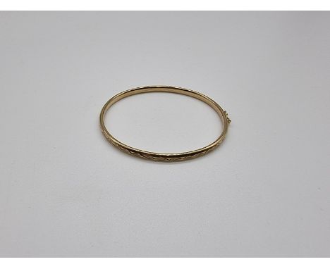 A yellow metal hollow bangle, stamped 9ct, 5g. 