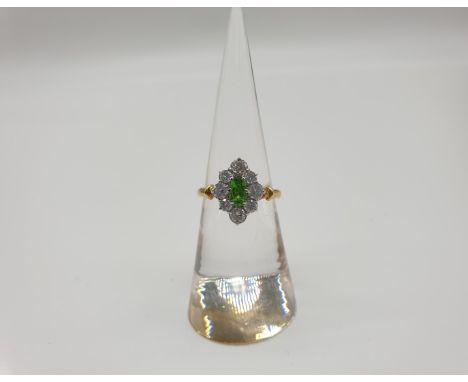 (NB) An 18ct gold cluster ring, set oval demantoid green garnet surrounded by eight brilliant cut diamonds, maker H.G, hallma