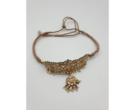 (NB) An unusual 19th century Indian yellow metal and coloured Jaipur enamel Bazuband, set with lasque diamonds and seed pearl