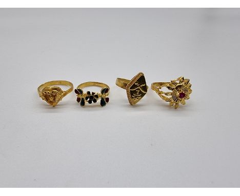 Four yellow metal rings, probably Iranian, one set a ruby and one having enamel decoration, gross weight 11.9g. 