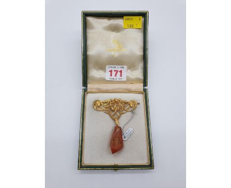 (NB) A cased Art Nouveau yellow metal brooch, having chased decoration of fir cones and foliage, with faceted amber drop, 72m