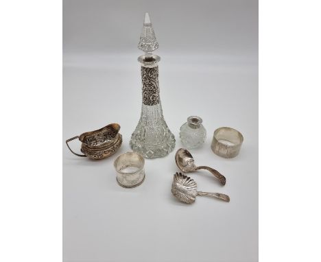 A small group of silver, comprising: a cream jug;&nbsp;two caddy spoons; a silver mounted cut glass scent bottle and stopper;