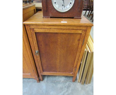 A 1930s light oak single door cupboard 