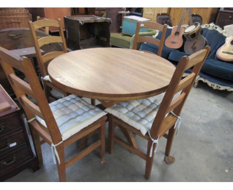 A medium oak extending dining table with four ladder back chairs 