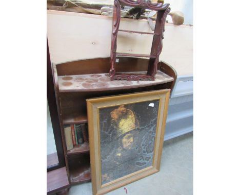 A bookcase with mixed books, a portrait print and small shelves 