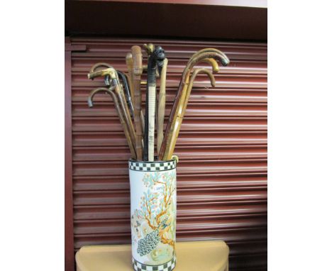 An Oriental stick stand containing 17 sticks, some with silver mounts