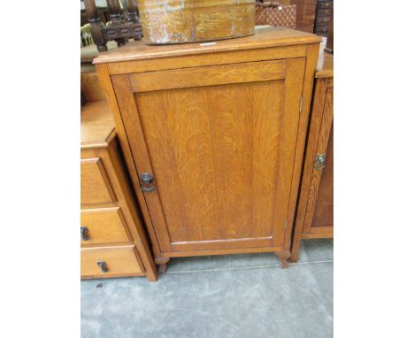 A 1930s light oak single door cupboard 