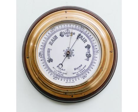 Circular brass ships type barometer on wooden back plate 