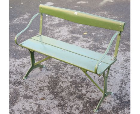 A green painted wooden garden bench on cast-iron end supports, 40¼” long. 