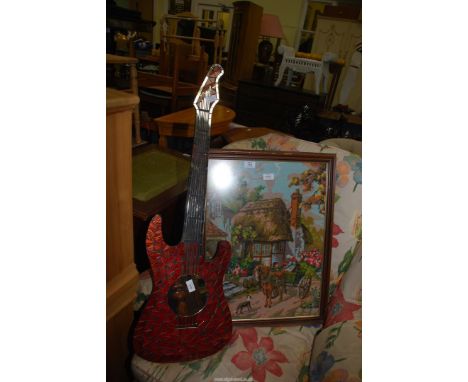 A mirror in the shape of a guitar and a tapestry of a cottage
