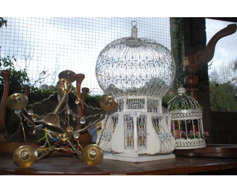 A large bird cage, small bird cage and a chandelier.