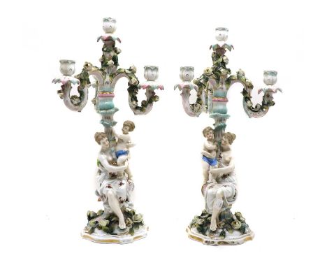 A near pair of Sitzendorf porcelain candelabra, 19th century, the three branches with heavily applied scrolling foliate decor