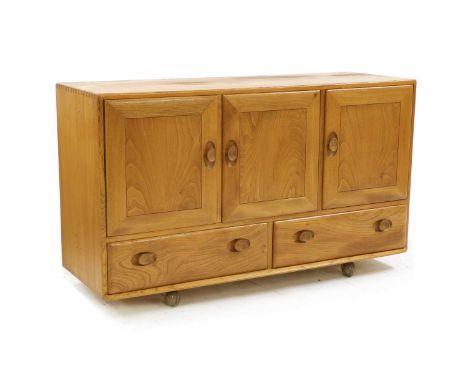 An Ercol low side cabinet, with three cupboards over two drawers, on castors, labelled with gold sticker,  129.5cm wide 45cm 