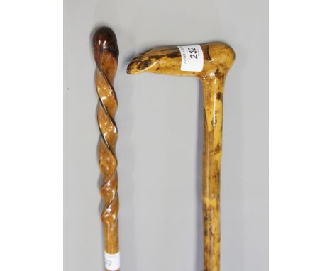 A walking stick, the handle carved as a foot, and another with twist carved stem 