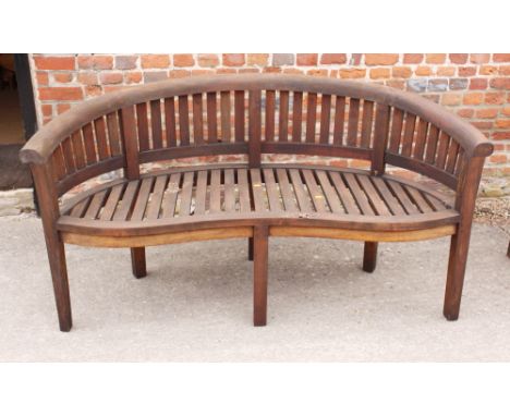 A curved slatted teak garden bench, 62" wide 