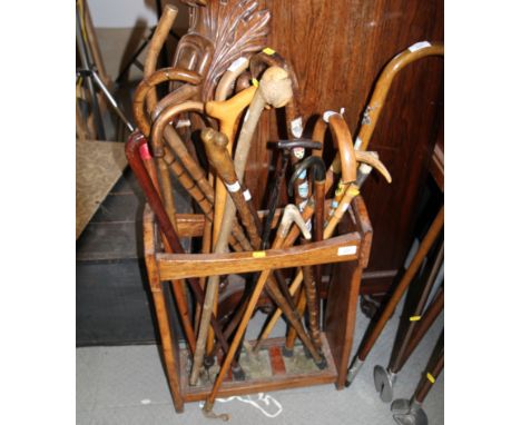 An oak stick stand a collection of assorted wooden walking sticks and riding crops 