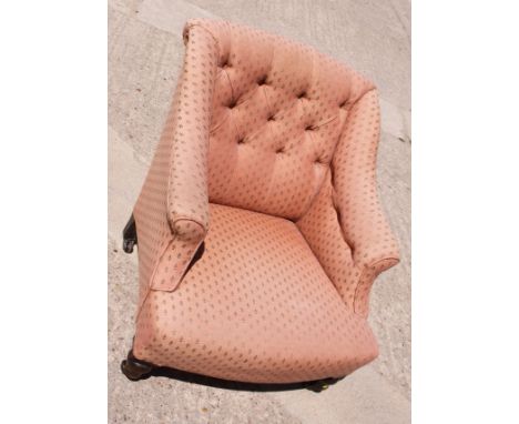 A Victorian low armchair with button back, upholstered in a pink fabric 