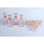A late 19th century Bohemian? set of four clear and cranberry glass decanters with gold painted