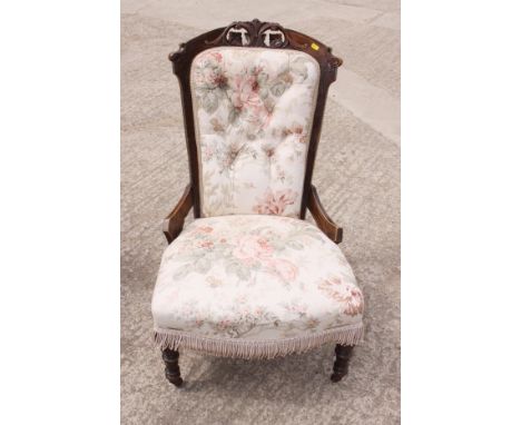 A Victorian stained frame nursing chair, upholstered in a floral print fabric 