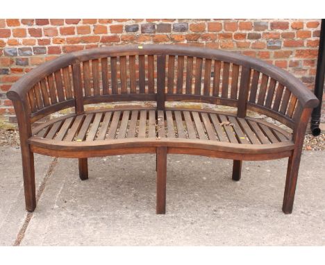 A curved slatted teak garden bench, 62" wide 