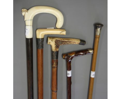 An ebony walking stick, with ivory handle carved a head, and four silver mounted walking sticks 