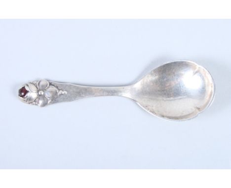 A Danish mid 20th century silver caddy spoon with hammered finish, the thumb piece moulded rose decoration with red hardstone