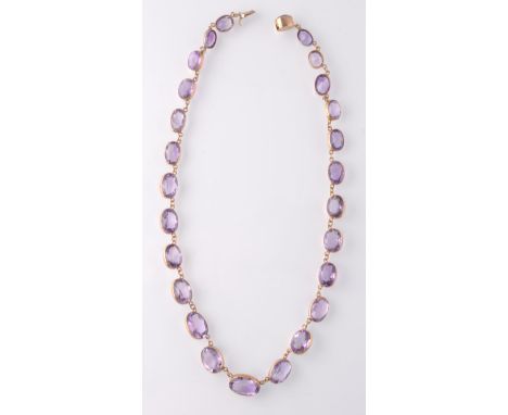 A 19th century gold and amethyst rivière&nbsp;necklace. The necklace strung with 26 oval mixed cut amethyst within collet set