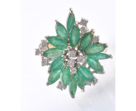 An 14ct gold emerald and diamond cluster dress ring. The ring being set with 15 marquise&nbsp;cut emeralds with single diamon