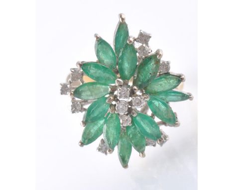 An 14ct gold emerald and diamond cluster dress ring. The ring being set with 15 marquise&nbsp;cut emeralds with single diamon