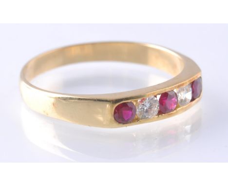 A hallmarked 18ct gold ruby and diamond 5 stone ring. The ring being having channel set rubies an diamond a raised band mount