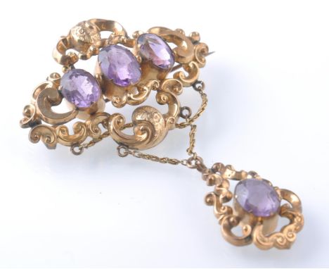 A 19th century gold amethyst drop pendant brooch. The brooch set with oval mixed cut amethyst within a rococo mount having pe
