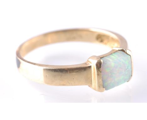 A 14ct gold and synthetic opal ring. The ring being set with a rectangular opal cabochon of synthetic origin within a contemp