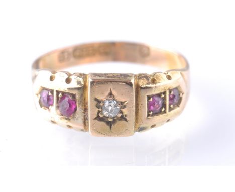 A Victorian 15ct gold diamond and ruby ring. The ring being set with a central old cut diamond flanked by four old cut rubies