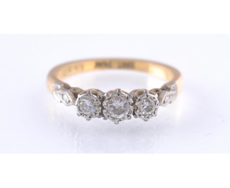 An early 20th century 18ct gold, platinum, three stone diamond ring. The ring having three illusion set diamonds with steel c